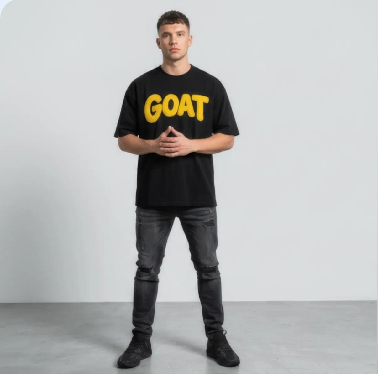 Athlete wearing a black GOAT t-shirt in a studio portrait